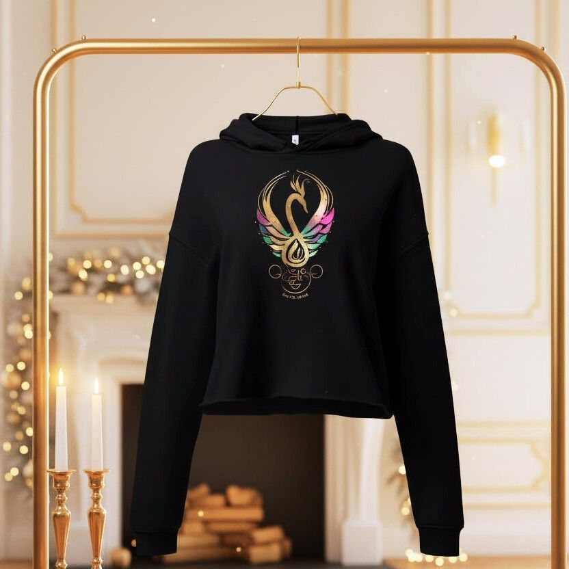 Black cropped hoodie with Mystic Glow swan symbol hanging on a clothing rack, Celtic Swan Collection.